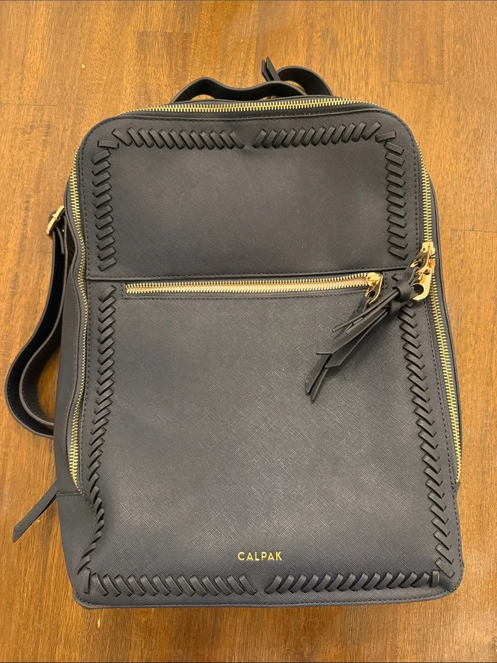 Calpak Black Leather Backpack with Gold Zippers and Woven Trim
